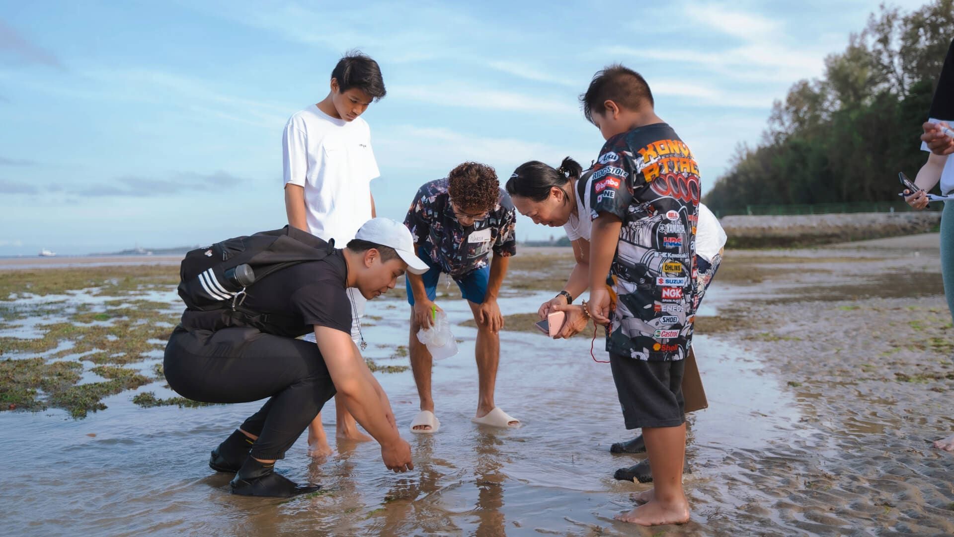 Volunteers and youths exploring the shoreline together at low tide